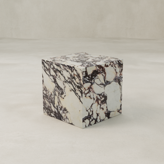 The Calacatta Cube Plinth features a white Calacatta Viola marble texture with dark brown and black veining, set on a light surface against a beige background—ideal for adding elegance to your decor.