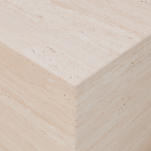 A close-up of the Alessia Plinths light beige travertine corner highlights its natural texture and subtle horizontal striations, making it a striking modern statement piece.