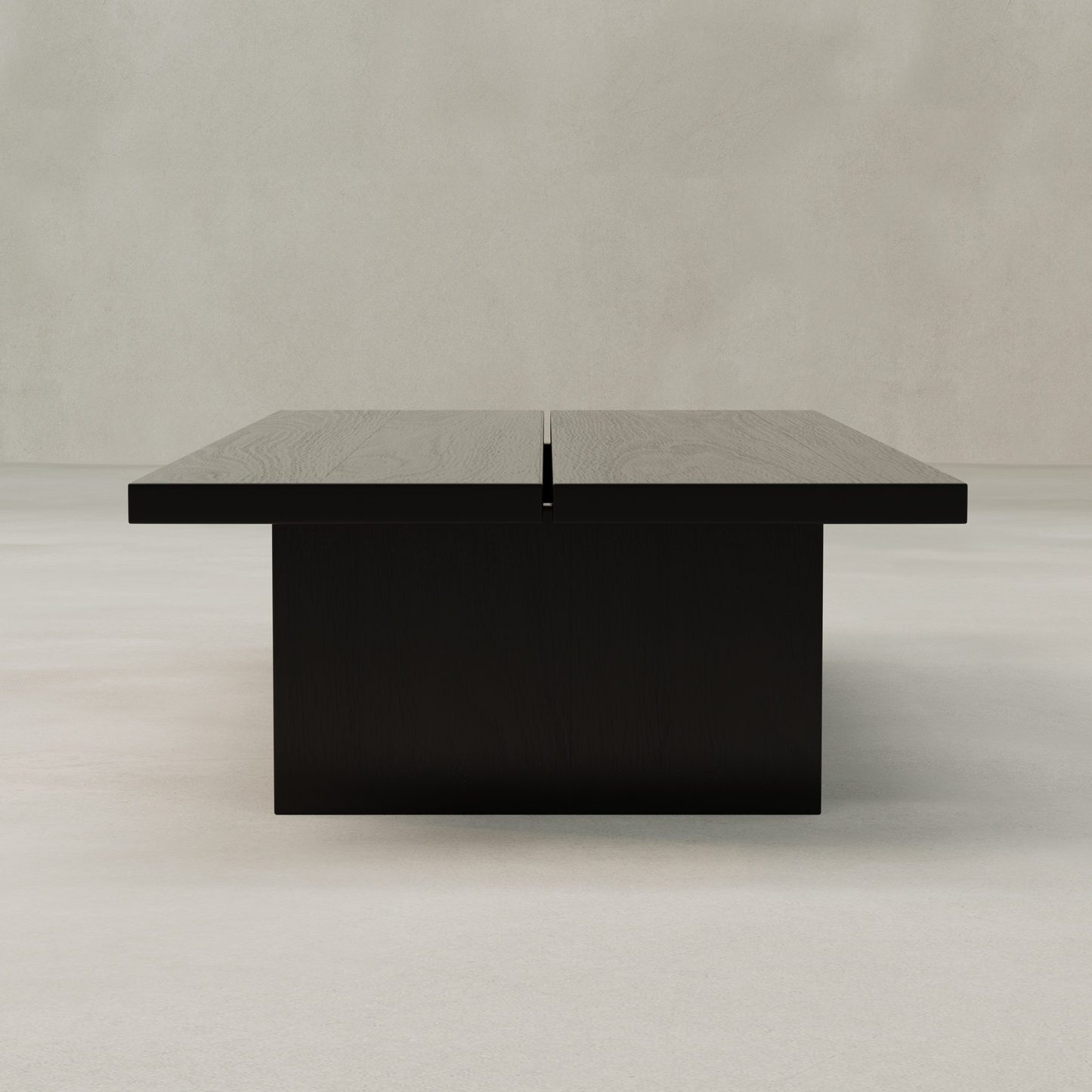 The Bastion Coffee Table features a minimalistic rectangular black design with a center split, adding rustic charm to any space. It’s shown against a plain light gray background.