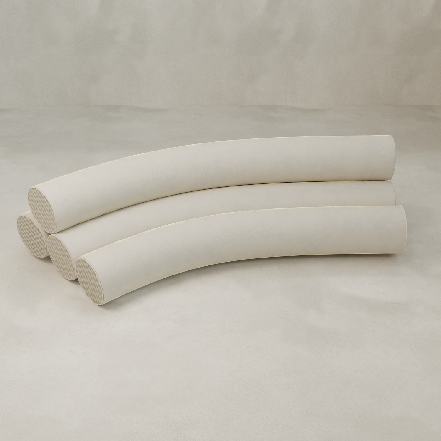 Three large, off-white cylindrical cushions are stacked parallel and slightly curved on a light background, evoking the playful, sculptural forms of the Cylindra Sofa in a minimalist, abstract arrangement.