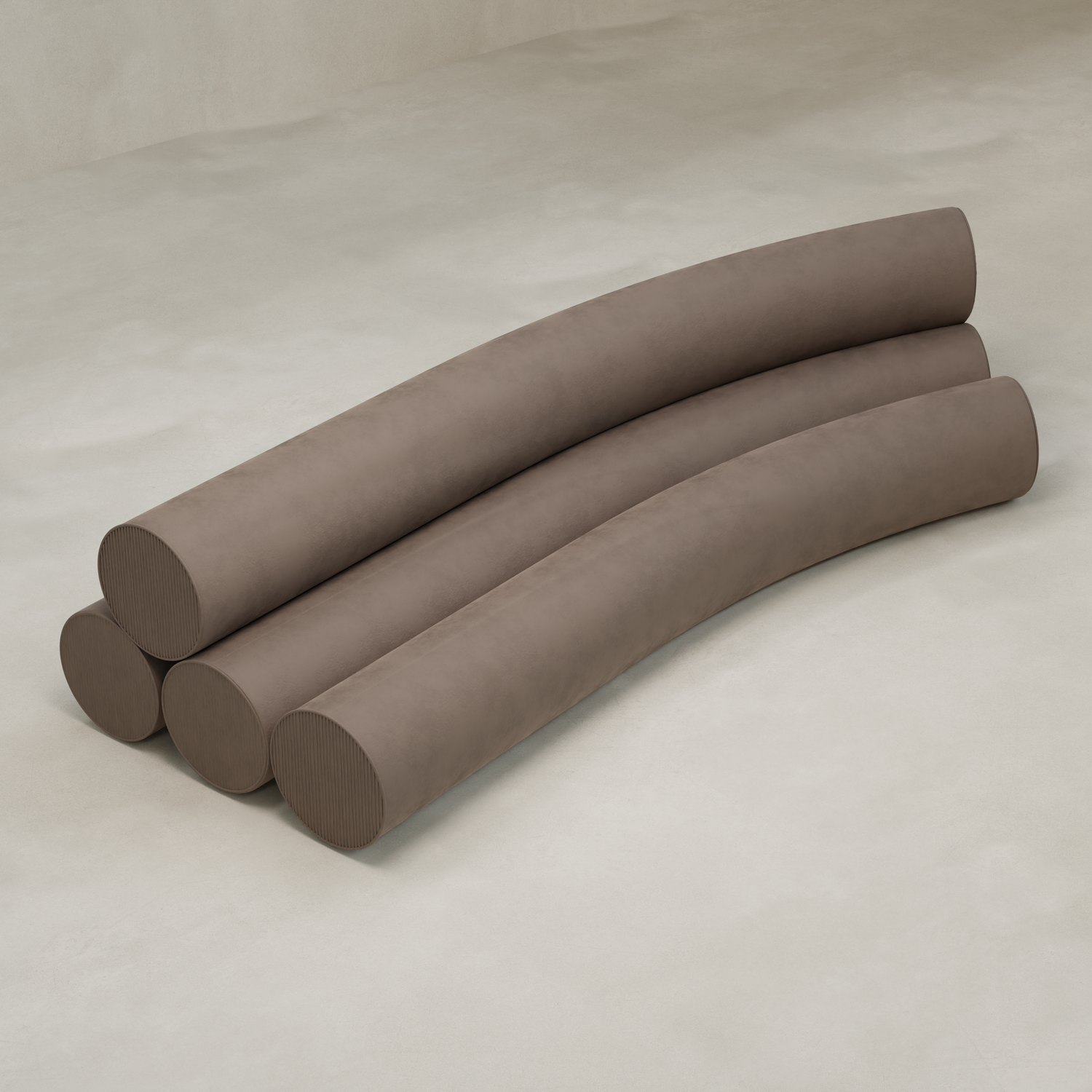 Four large, cylindrical, brown cushions are stacked horizontally and slightly curved, forming the Cylindra Sofa. The sofa sits on a light-colored, smooth floor against a plain background.