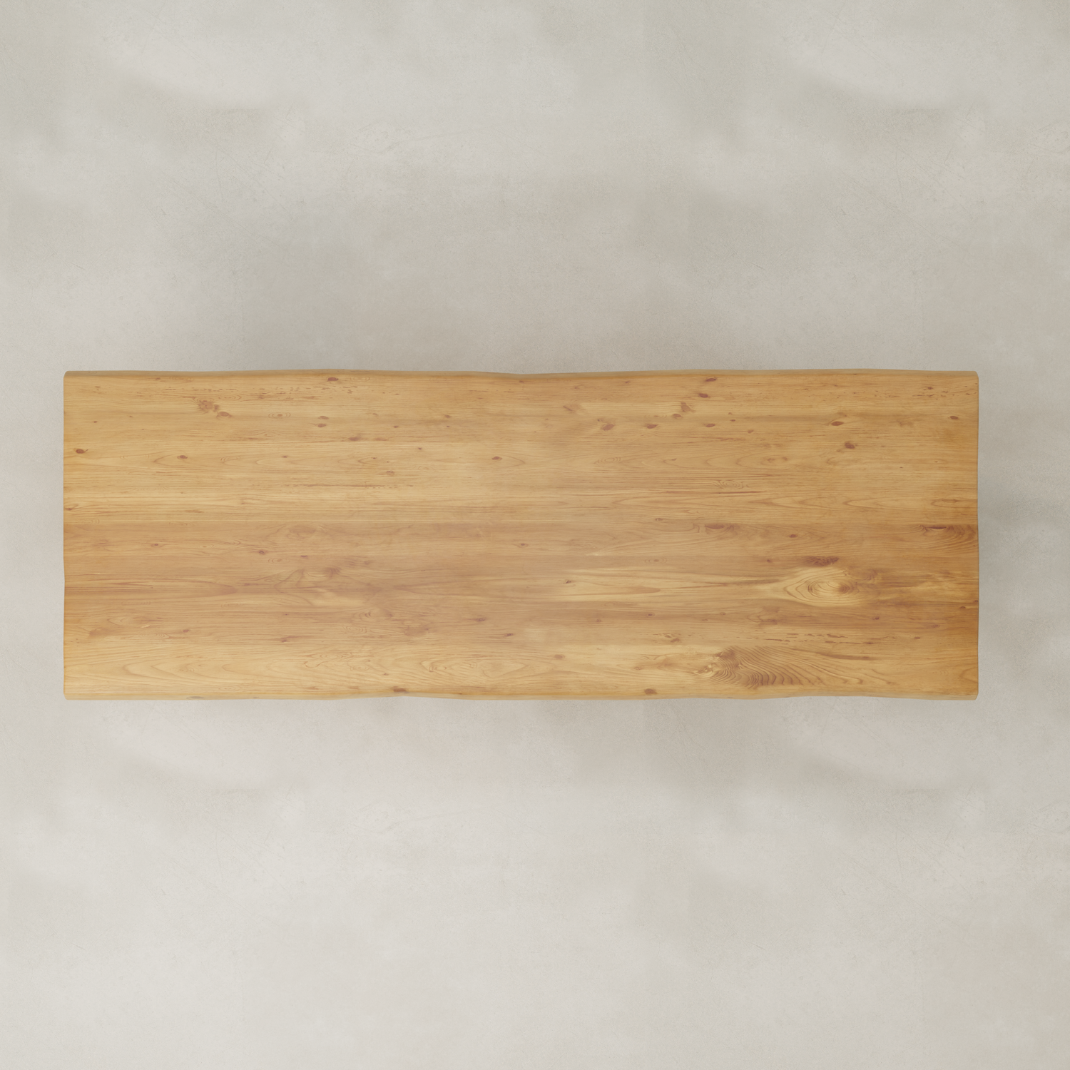 A rectangular Elm Farmhouse Table Large with a smooth, natural finish and visible wood grain patterns sits atop a light, textured floor, offering rustic charm inspired by modern farmhouse style.