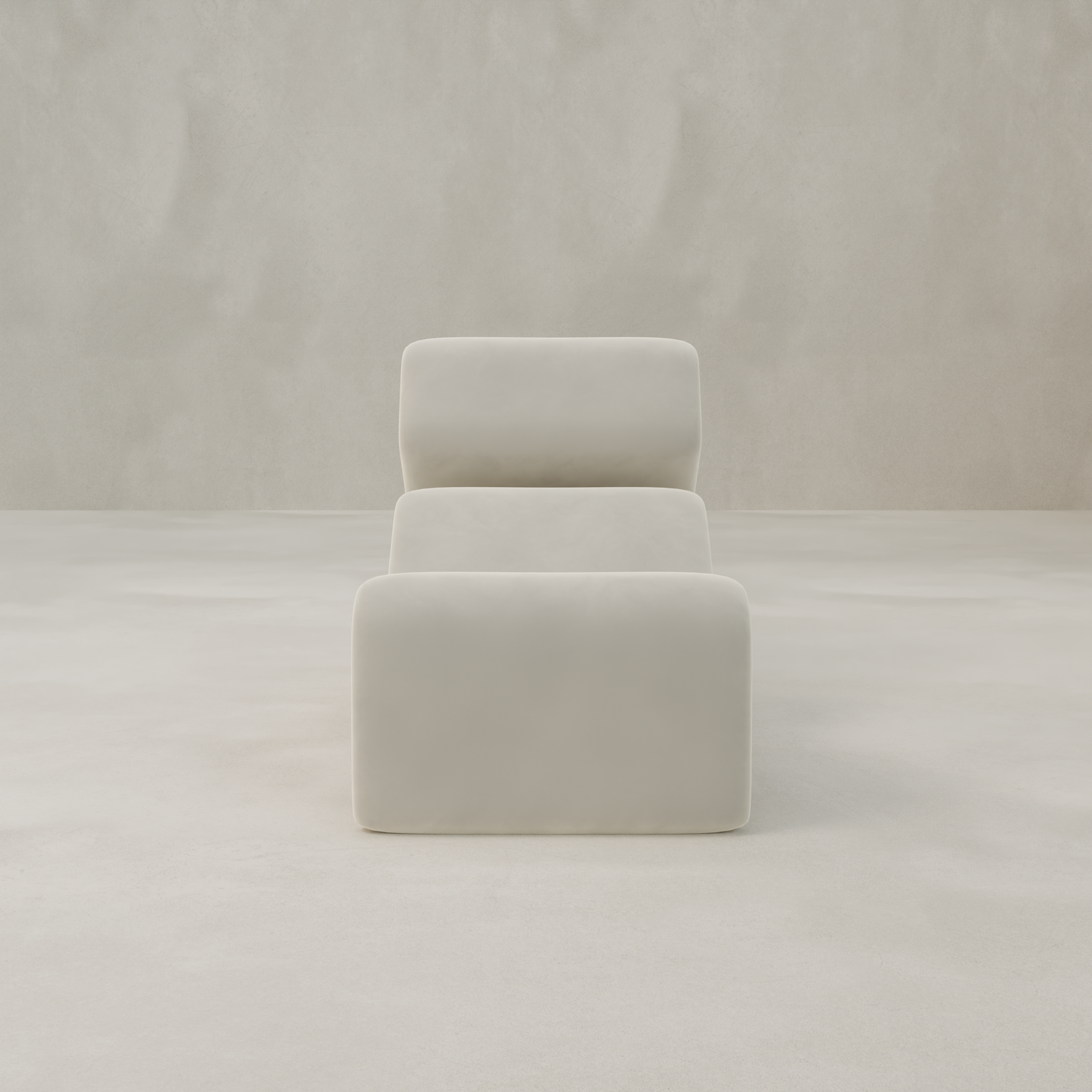 The Infinity Chaise Lounge, a modern white chair with smooth, rounded edges and velvet upholstery, features clean lines and a soft, cushioned look. It sits centered against a light, textured background for a minimalist feel.