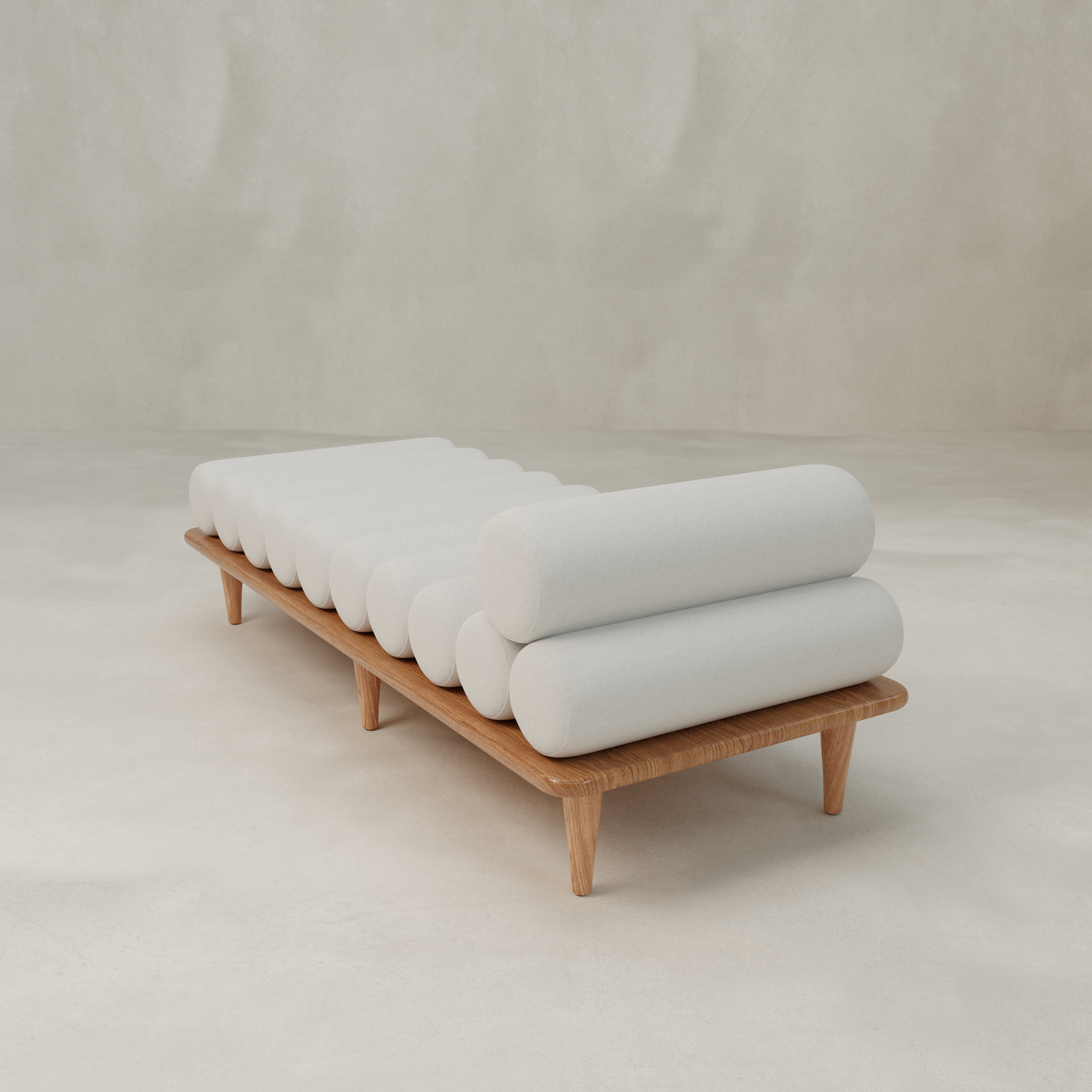 The Kingston Daybed features a wooden frame and cylindrical light gray cushions arranged horizontally, bringing minimalist style to a neutral, empty room.