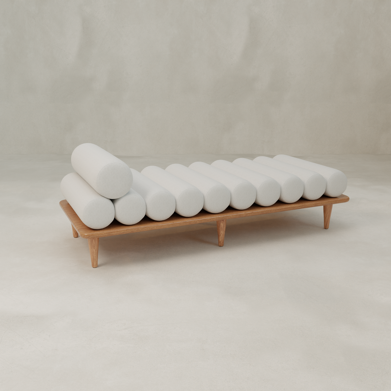 The Kingston Daybed features a wooden frame with evenly spaced cylindrical white cushions, set against a neutral, minimalist background.
