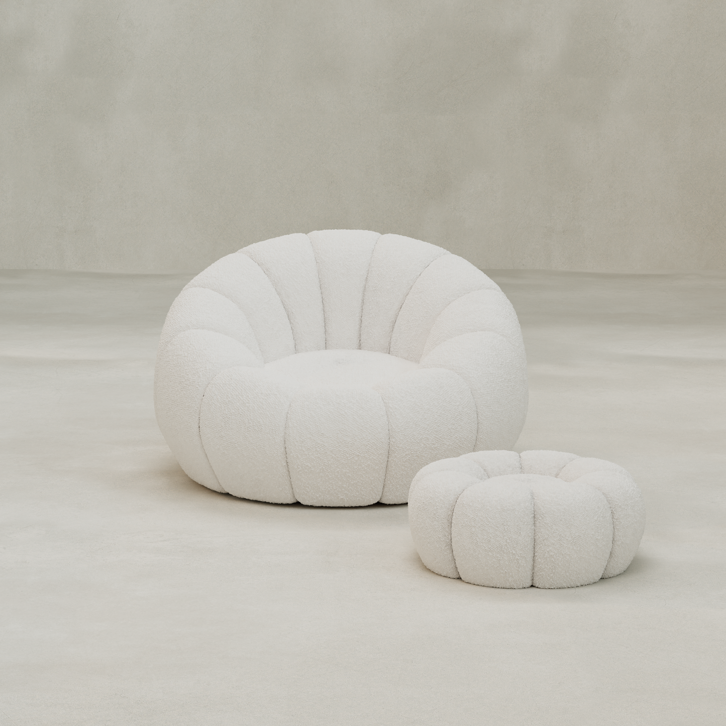 The Penelope Chair features plush white bouclé with scalloped sections and includes a matching ottoman, ideal for a cozy reading nook in neutral, minimal spaces.