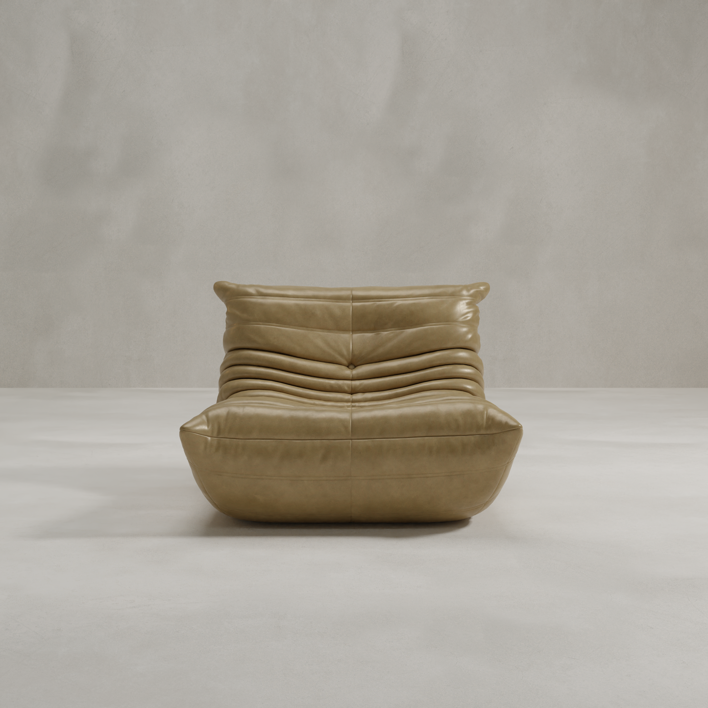 The Rolo Lounge Chair is a modern, tan leather seat with 70s-inspired style, featuring a low profile and horizontal tufting, shown in a minimal light gray room with smooth floors and a plain textured wall.