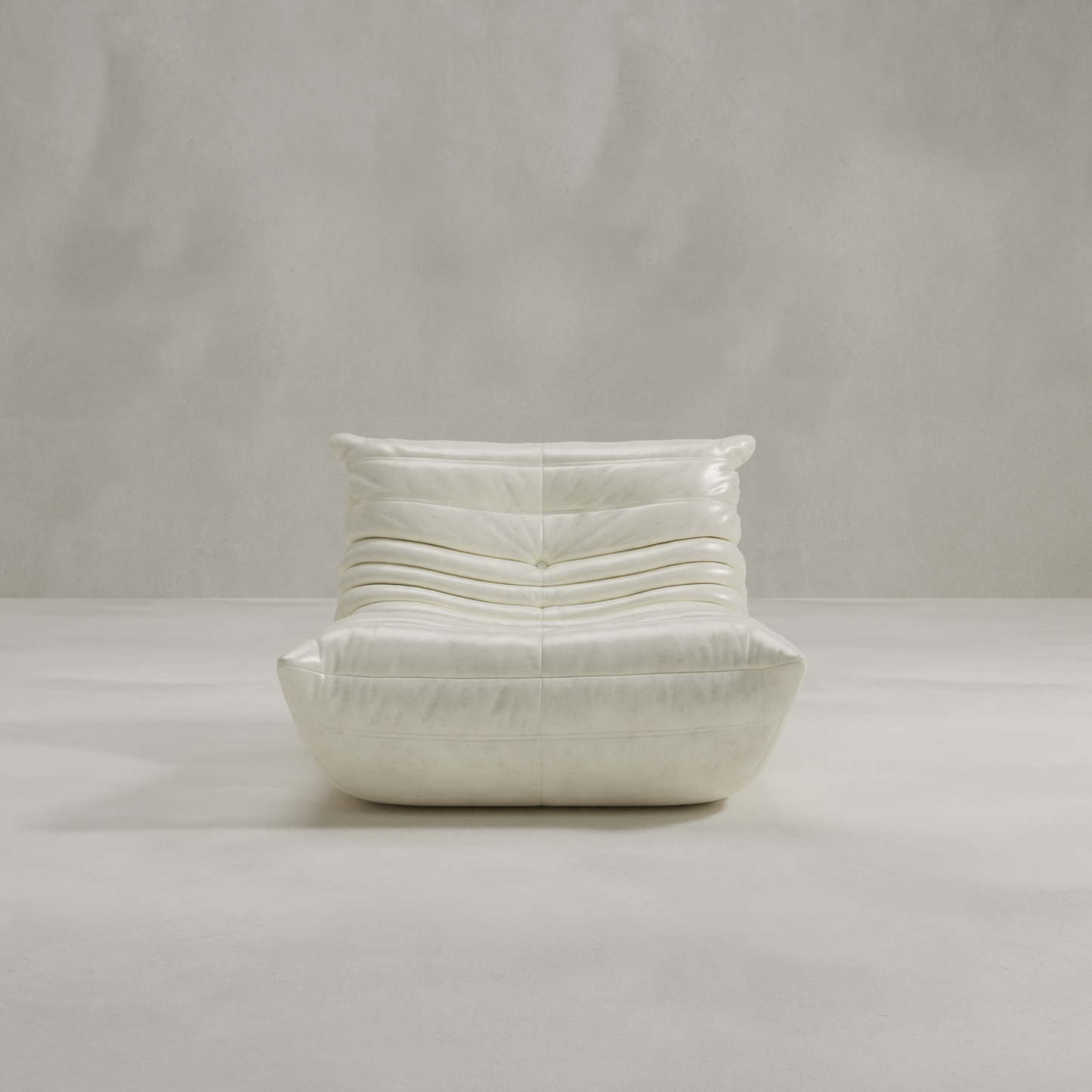 The Rolo Lounge Chair is a modern, low-profile white leather lounge chair with soft, gathered cushions and mid-century design cues, shown against a plain light gray textured background.