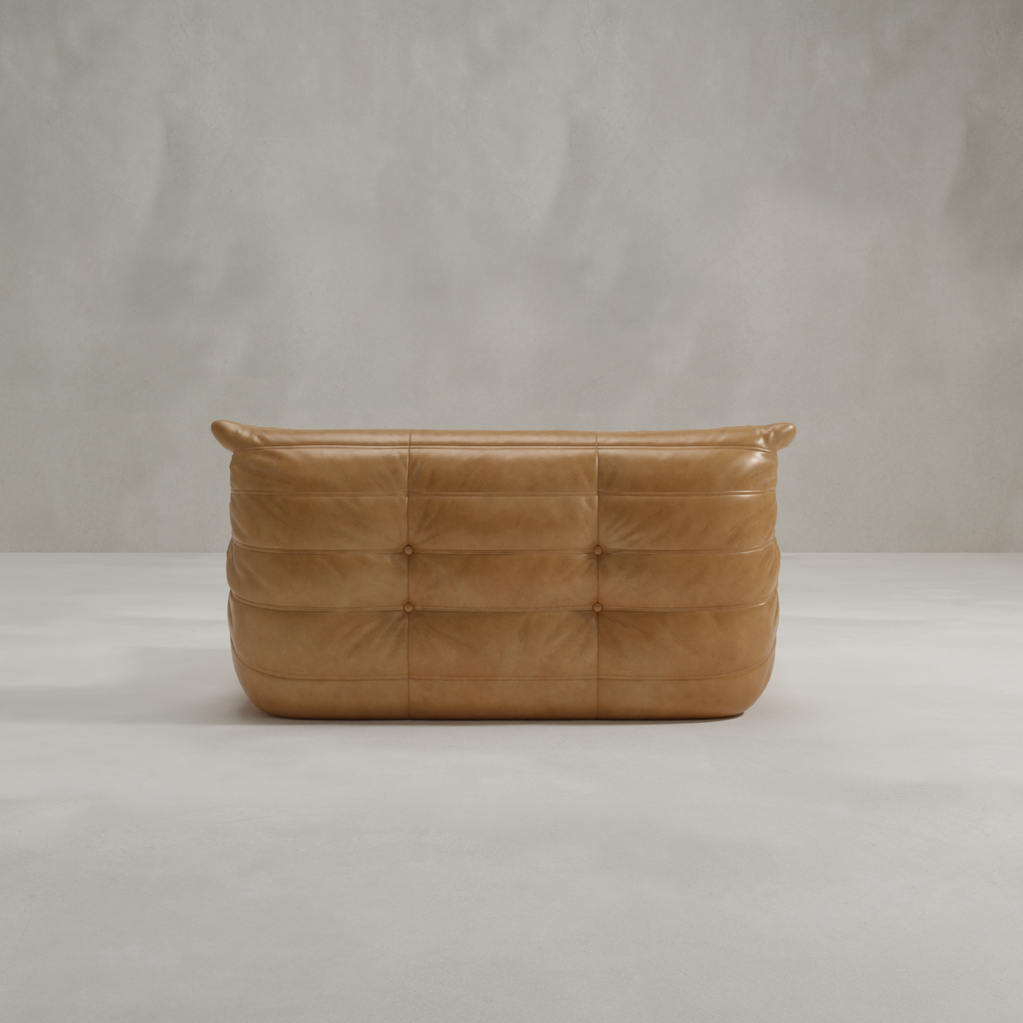 The Rolo Lounge Loveseat, a modern tan leather sofa with tufted cushions and subtle mid-century style, sits on a smooth, light gray floor against a plain, textured gray wall.