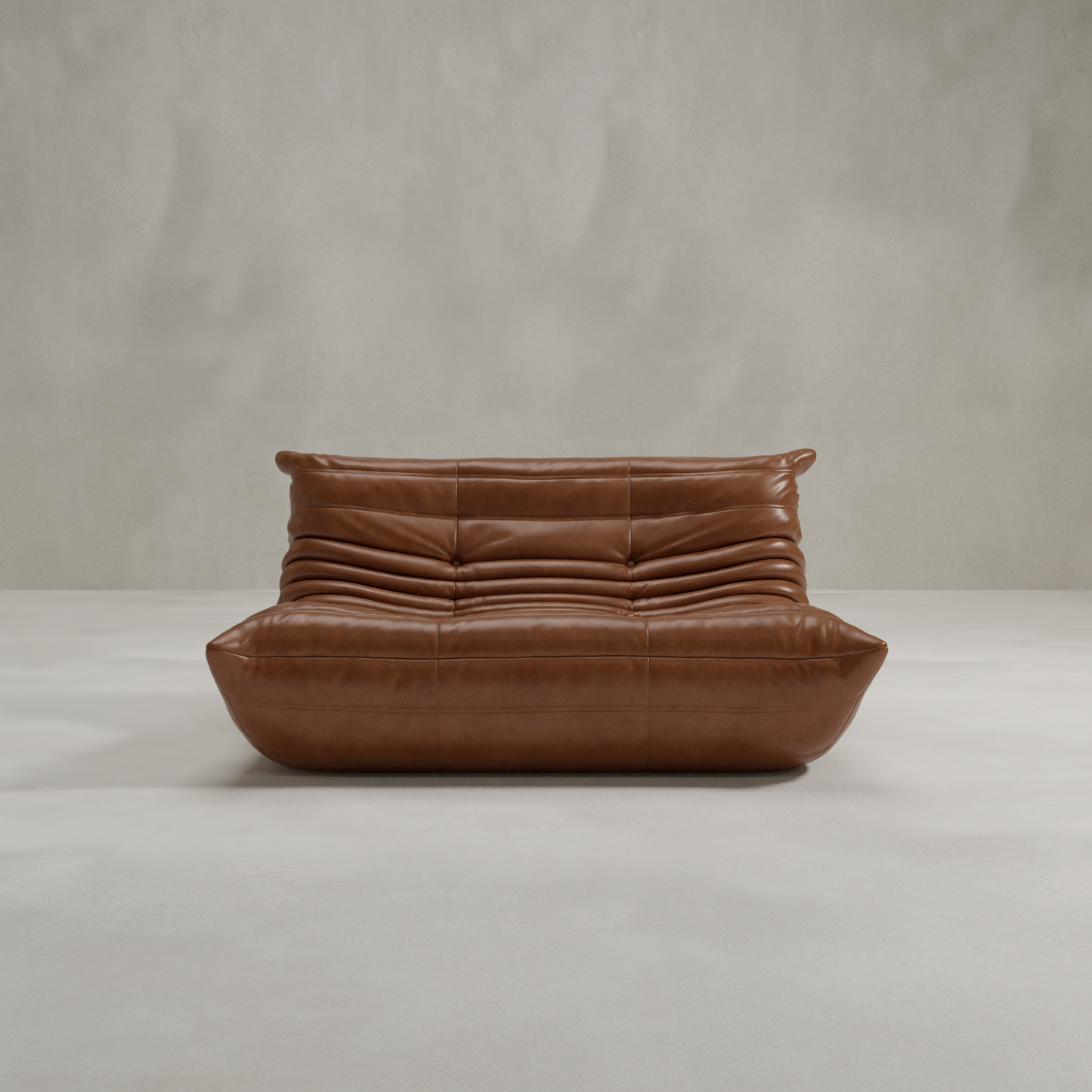 The Rolo Lounge Loveseat features a modern brown leather design with a low profile, deep seat, and ruched cushions inspired by mid-century style, showcased against a plain light gray background.