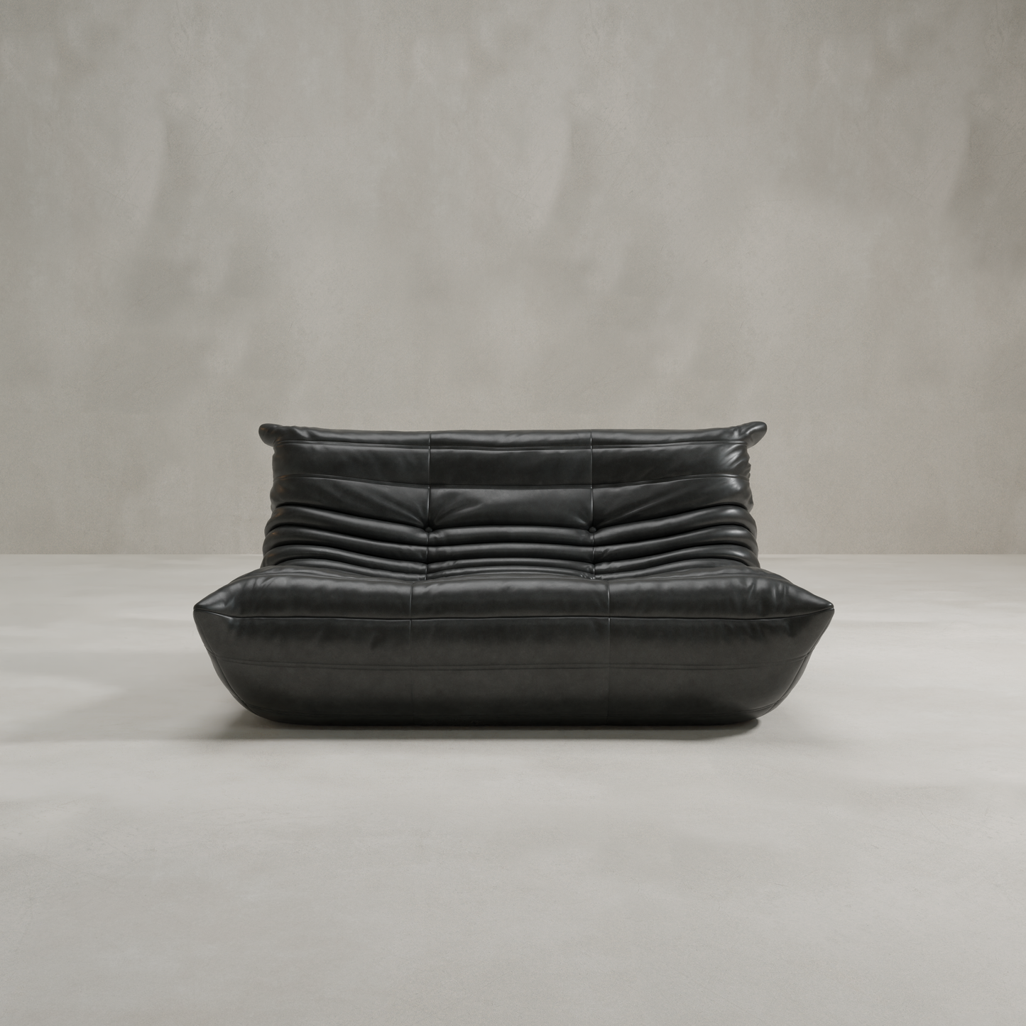 The Rolo Lounge Loveseat is a modern black leather sofa with a low profile, plush curved cushions, and horizontal tufting that channels mid-century design, perfect for minimalist rooms with light walls and floors.