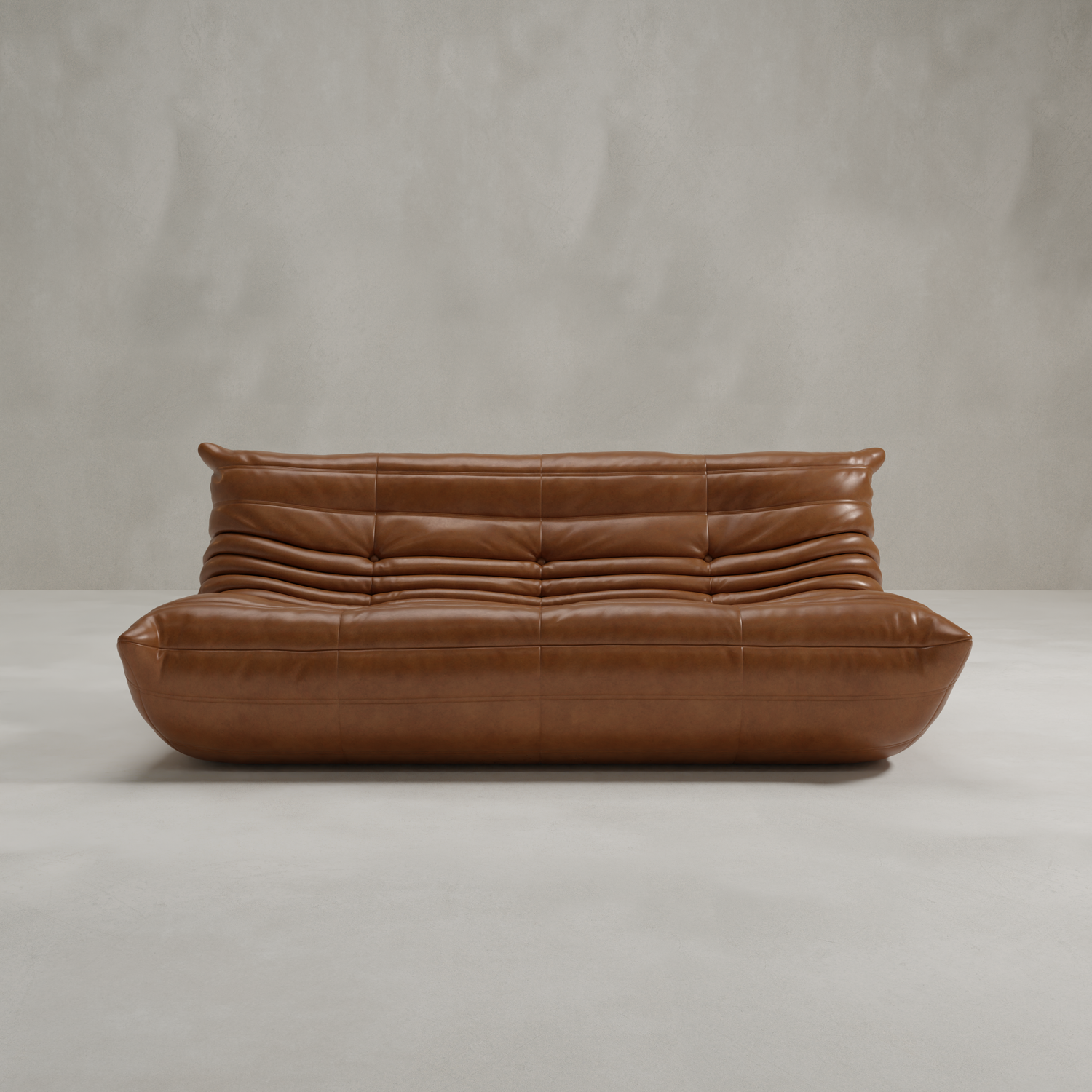 The Rolo Lounge Three Seater features modern brown leather, a low profile, tufted cushions, and soft wavy lines in mid-century style, set against a minimalist light gray wall and floor backdrop.