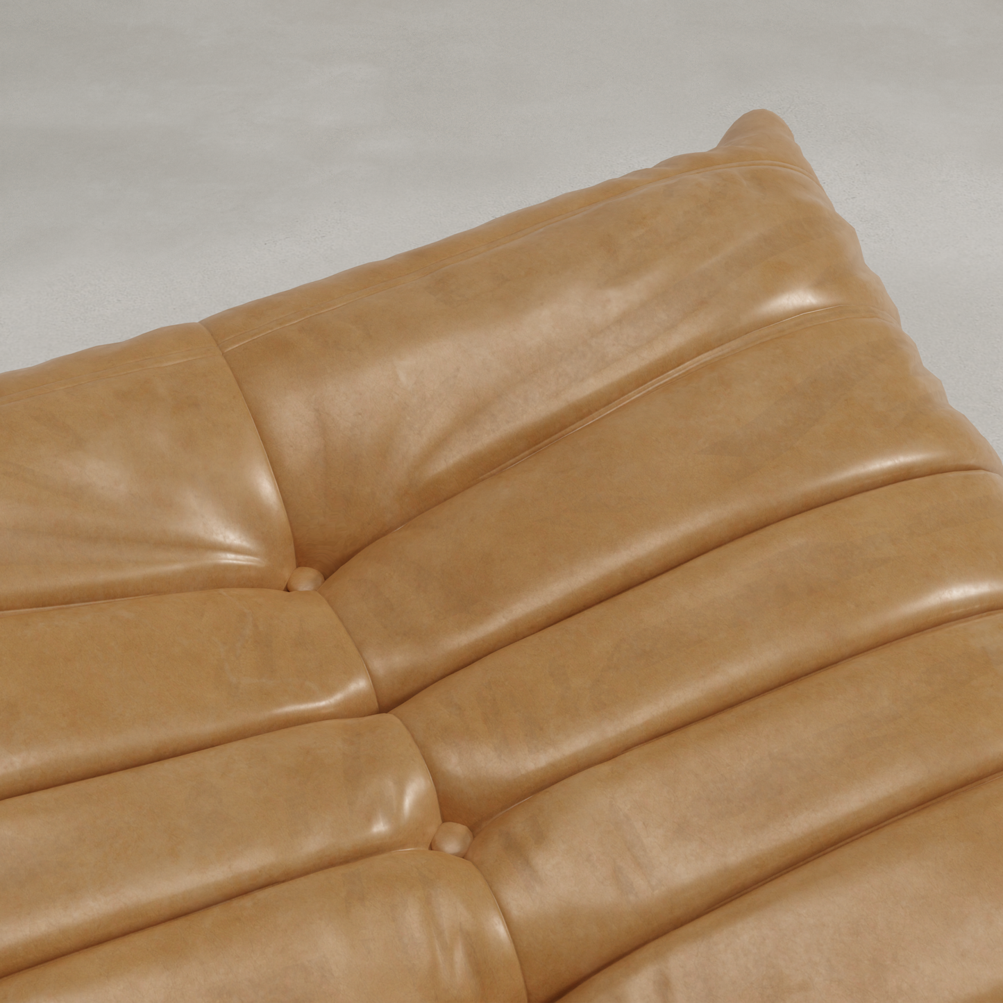 Close-up of the Rolo Ottoman in tan leather, featuring visible stitching and button tufting on a light gray surface. Its smooth, slightly glossy finish makes it ideal for use as extra seating or a cushioned footstool.