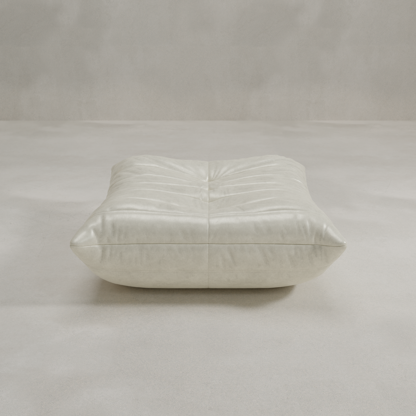 The Rolo Ottoman is a low, square, light gray floor cushion with soft tufted detailing, perfect for extra seating or use as an ottoman in any neutral space.
