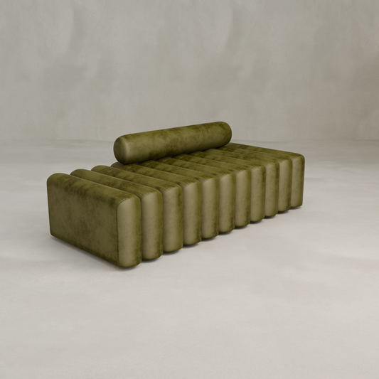 The Sonorra Bench Large, a modern olive green velvet daybed with quilted upholstery, cylindrical bolster pillow, and ribbed vertical cushion design, is displayed on a light plain background.
