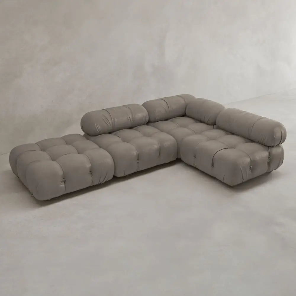 The Belmont Sofa Combination C features marshmallow-like curves, tufted plush cushions, and cylindrical headrests, all upholstered in light gray fabric and displayed against a plain light gray background.