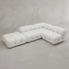 The Belmont Sofa Combination C is a modern, L-shaped modular sofa with marshmallow-like curves, tufted white upholstery, and rounded edges, displayed against a plain light grey wall and floor.