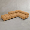 The Belmont Sofa Combination C, a modular tan sectional with tufted, marshmallow-like curves and cylindrical back and arm supports, is arranged in an L-shape against a plain gray wall and floor.