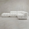 The Belmont Sofa Combination C, a modern modular white sectional with plush tufted curves, is set against a plain light gray wall and floor background.