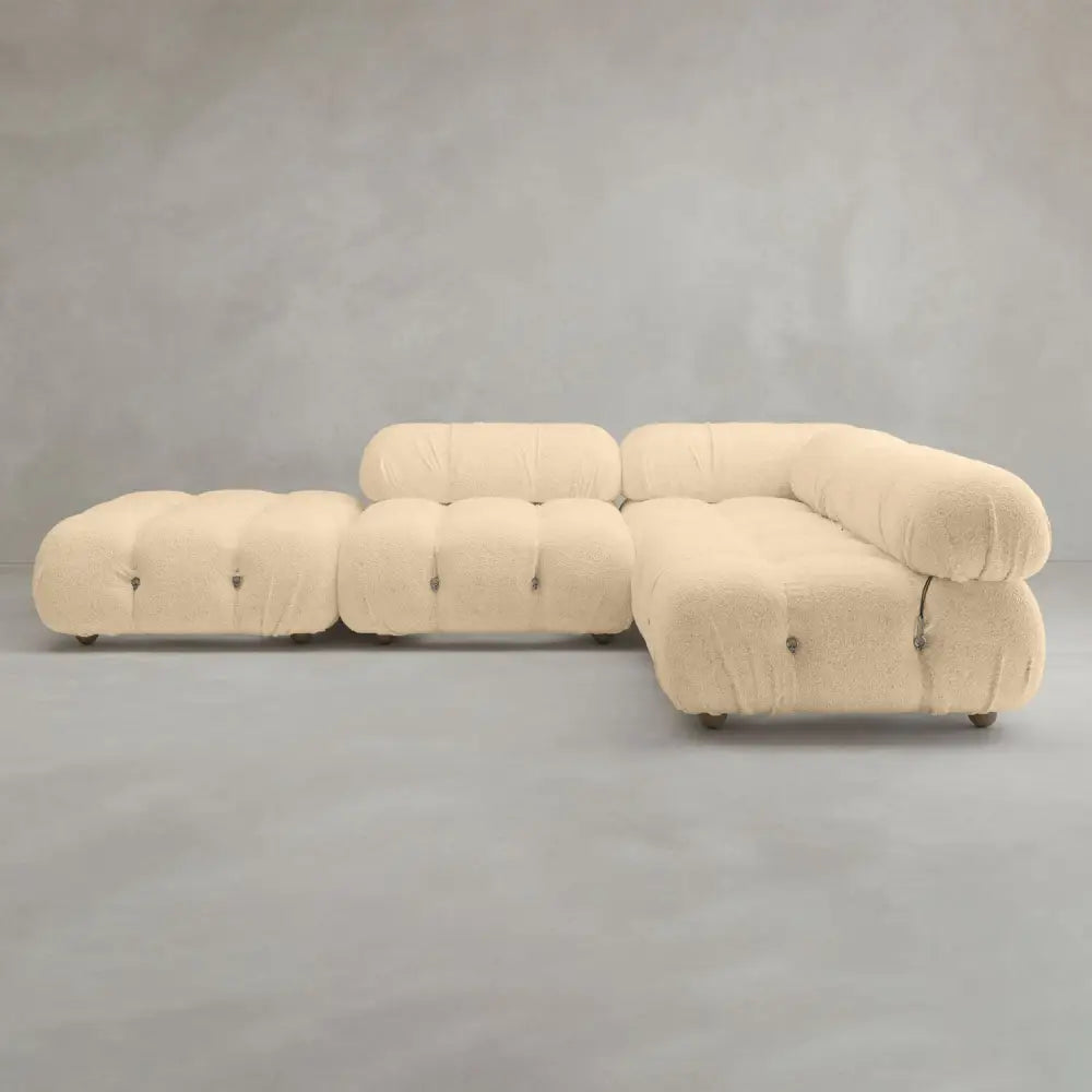 The Belmont Sofa Combination C features a modern, modular cream design with marshmallow-like curves, tufted cushions, and rounded edges, displayed against a plain gray background.
