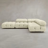 The Belmont Sofa Combination C is a modern, modular cream-colored sectional with tufted cushions and marshmallow-like curves, rounded edges, and set against a plain gray background.