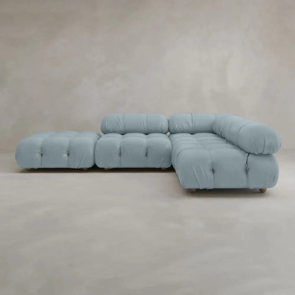 The Belmont Sofa Combination C is a light blue, tufted sectional with marshmallow-like curves, plush cushions, and a modern minimalist modular design featuring three main seating sections set against a plain light beige background.