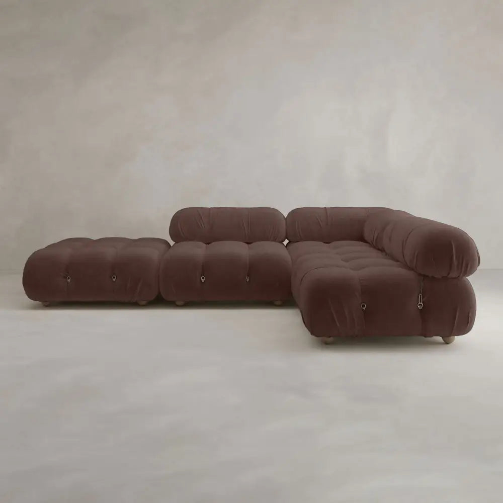 The Belmont Sofa Combination C is a modern, modular brown sectional with marshmallow-like curves, tufted cushions, and rounded edges, set against a neutral textured wall and floor.