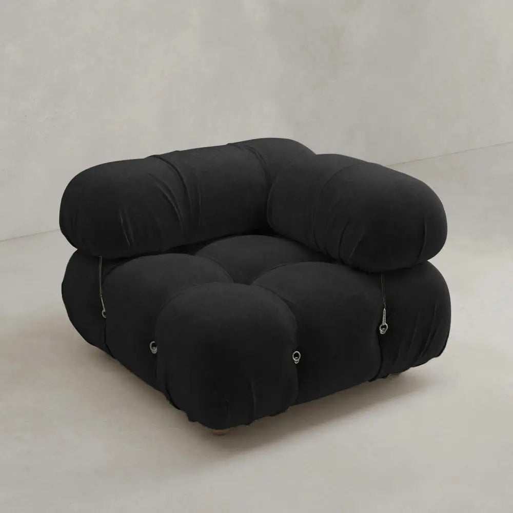 The Belmont Sofa Left Armrest is a black, modern modular seat with plush, rounded cushions and visible seams, shown against a plain light gray background.