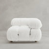 The Belmont Sofa Left Armrest features a plush, modern white design with marshmallow-like curves, tufted upholstery, minimalist metal accents, and modular elements. It is shown against a plain light gray background.