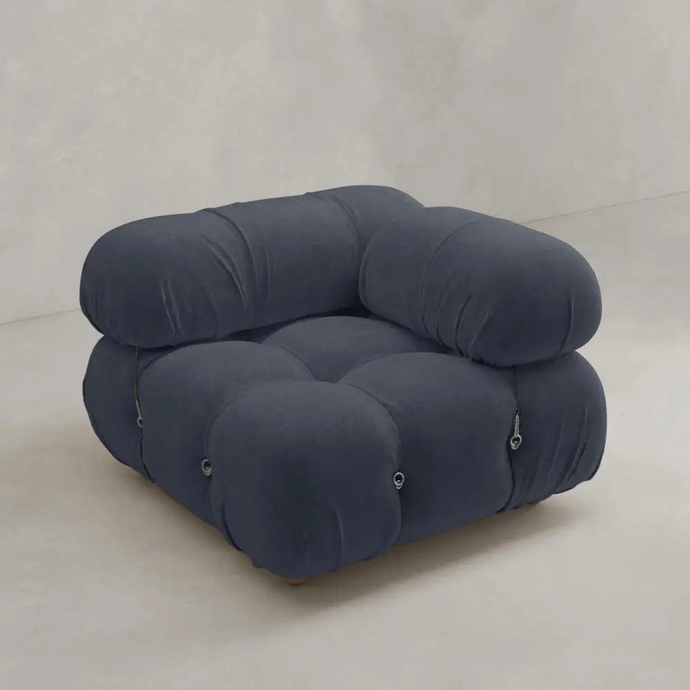 The Belmont Sofa Left Armrest features a modern, dark gray design with marshmallow-like curves, plush tufted upholstery, and rounded overstuffed cushions set against a plain, light-colored background.