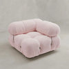 A plush, light pink Belmont Sofa Left Armrest features oversized, rounded cushions and visible tufted buttons, evoking a cloud-like feel and set against a plain, light-colored background.