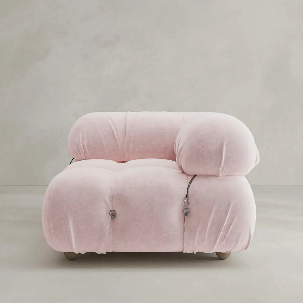 The Belmont Sofa Left Armrest is a modern, plush seat with soft pale pink upholstery, marshmallow-like curves, rounded cushions, and visible button details, pictured against a plain light background.
