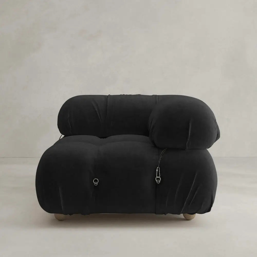 The Belmont Sofa Left Armrest features a modern, overstuffed black design with rounded edges and silver hardware, adding an iconic classic touch to any minimalist space.