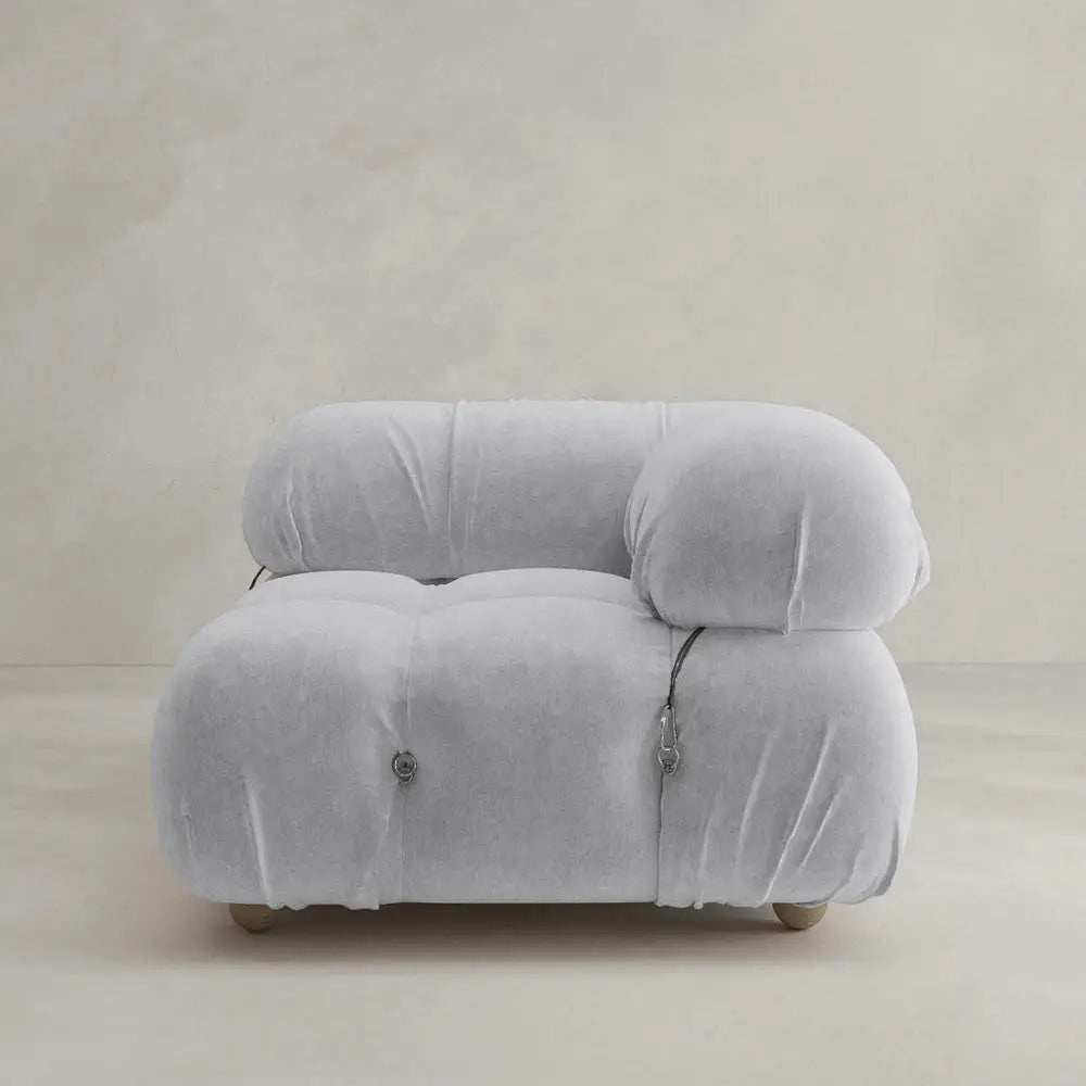 The Belmont Sofa Left Armrest features a modern, plush design in light gray with marshmallow-like curves, rounded and overstuffed for comfort, visible seams, and set against a plain beige background.