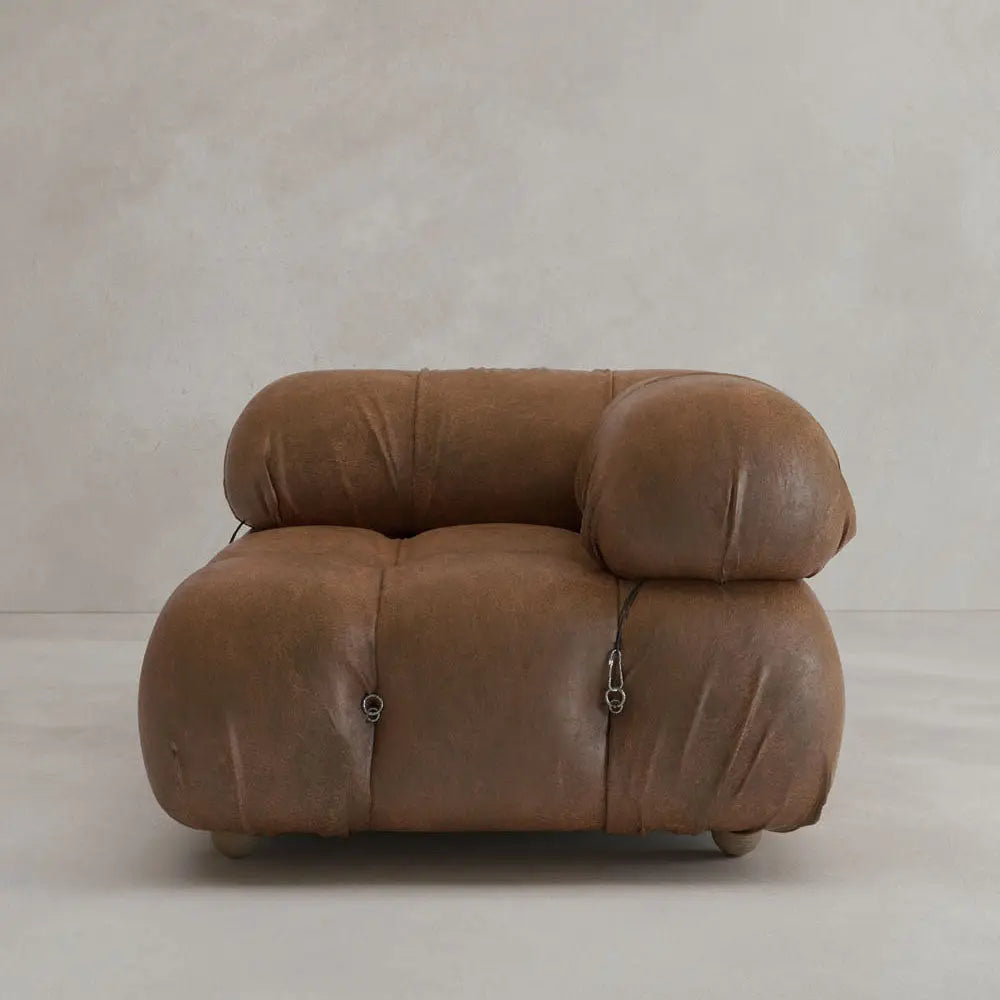 The Belmont Sofa Left Armrest features plush, oversized brown leather cushions with metal fasteners for a classic, iconic look—perfect against a light-colored wall and floor.