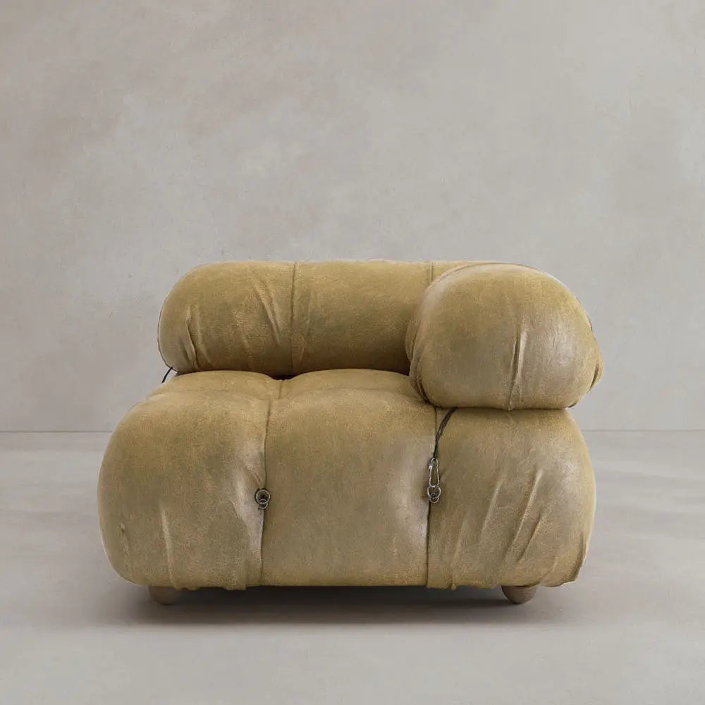 A plush, tan Belmont Sofa Left Armrest with rounded, overstuffed cushions and visible metal fasteners showcases a modular design against a plain light gray background.