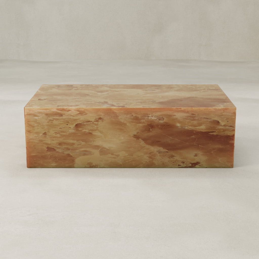 The Ambeline Onyx Coffee Table features sculptural design and warm brown-amber tones, bringing organic elegance to any space when placed against a light, neutral background.