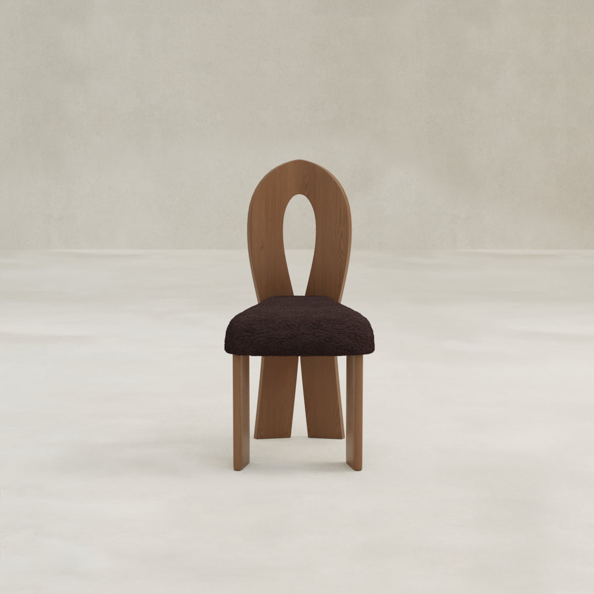The Aveline Dining Chair features a unique teardrop backrest and a dark, textured upholstered seat, shown on a light floor with a neutral textured wall background.