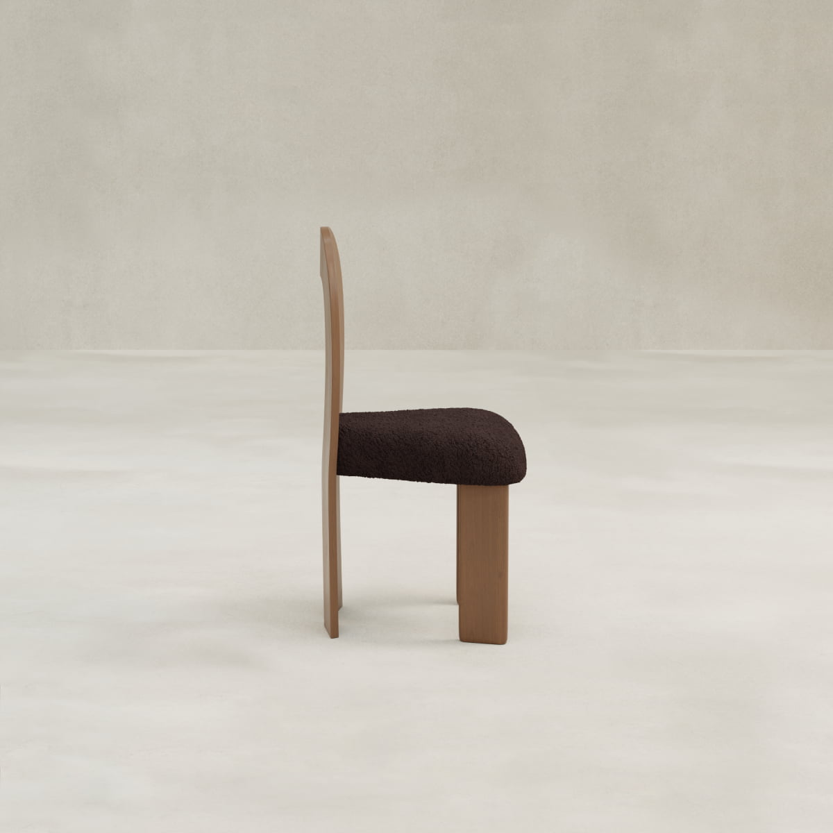 The Aveline Dining Chair features a wood frame, flat backrest, and plush upholstered seat cushion, shown in profile against a light, textured background.