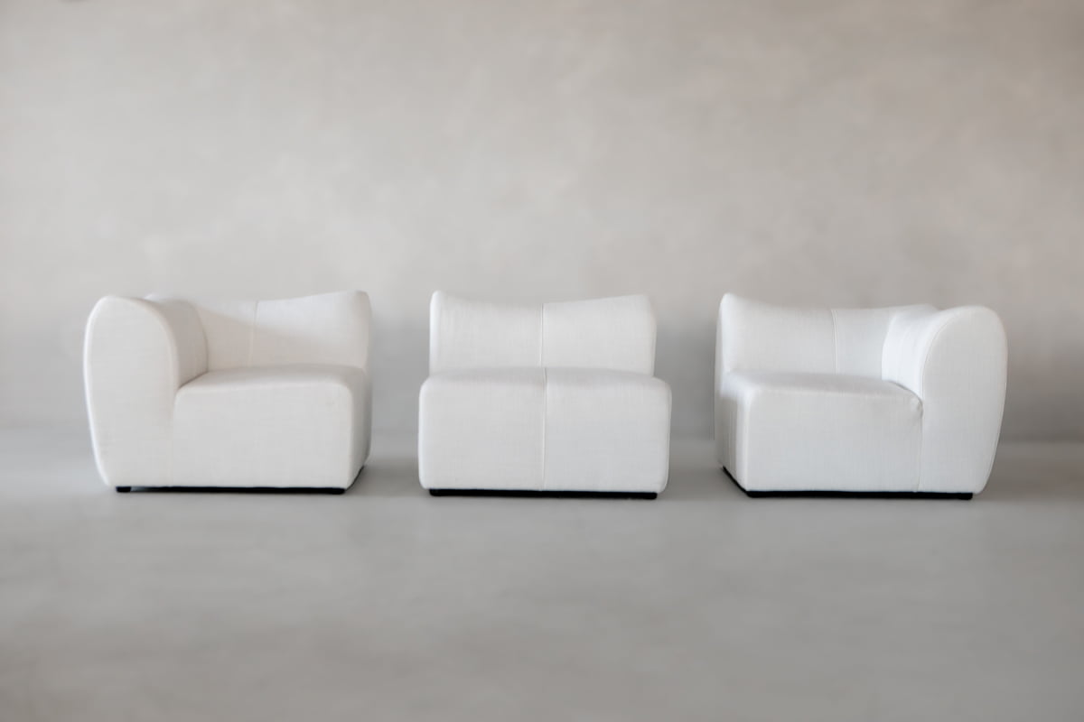 The Bambon 3 Piece Sofa Set features three modern, armless white chairs with curved edges arranged side by side against a light grey backdrop—an ideal minimalist addition for any contemporary living space.