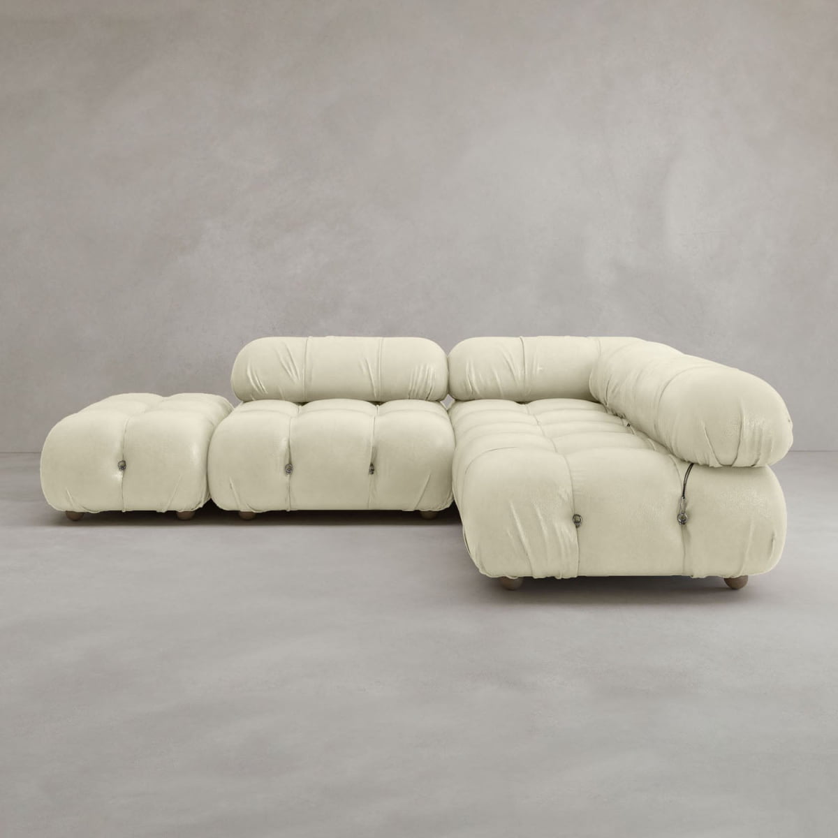 The Belmont Sofa Combination B is a modern, modular sofa with an ottoman in soft cream fabric, featuring plush tufted cushions and rounded edges—a cloud-like design that evokes a classic look against a light gray background.