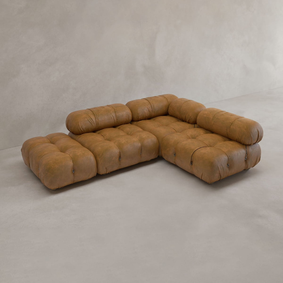 The Belmont Sofa Combination B is a modular sofa inspired by the iconic cloud design, featuring tufted brown leather upholstery and rounded cushions, showcased against a light beige minimalist background.