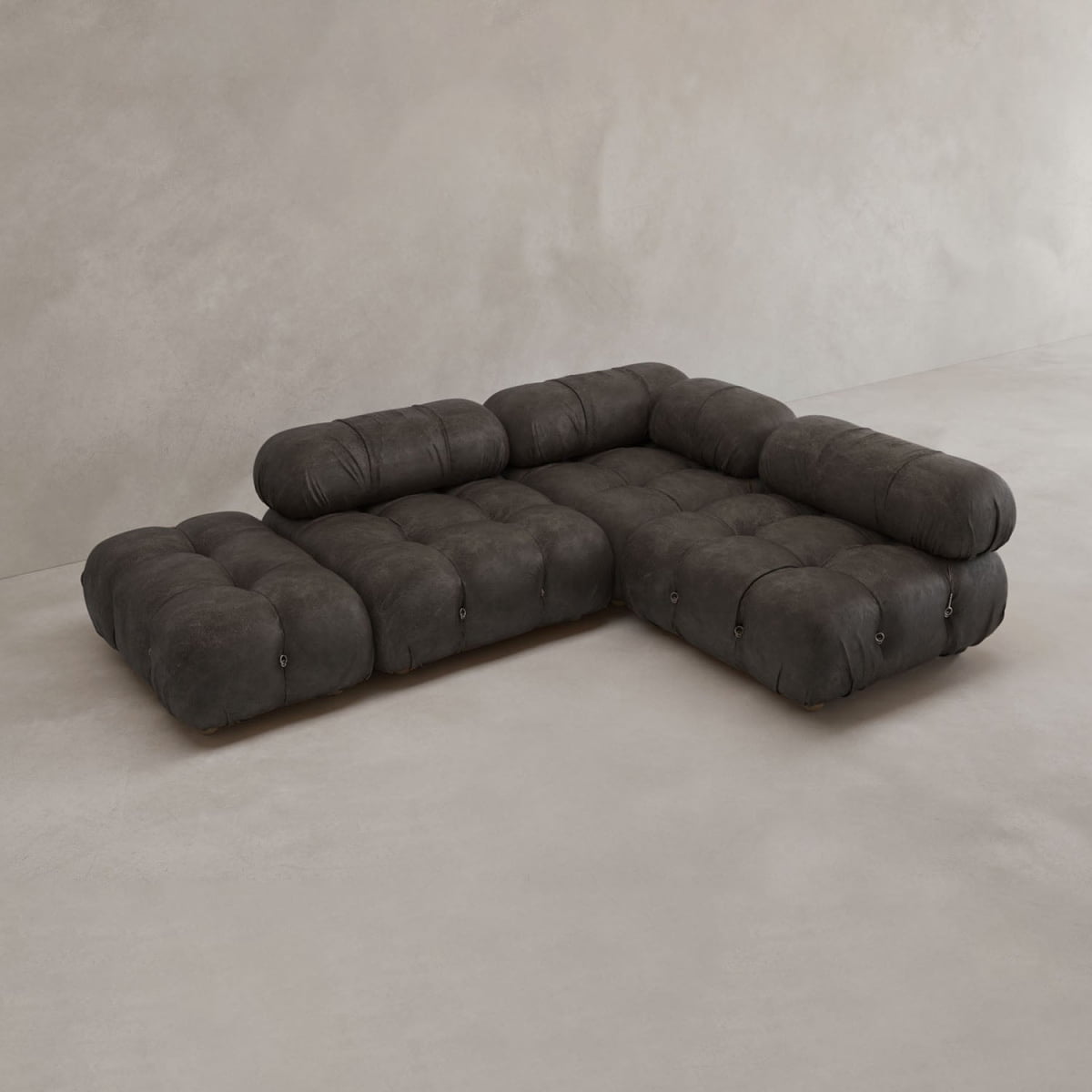 The Belmont Sofa Combination B is a modern, dark gray modular sofa with tufted design, low backrests, and plush cushions, set on a smooth light floor against a neutral wall.