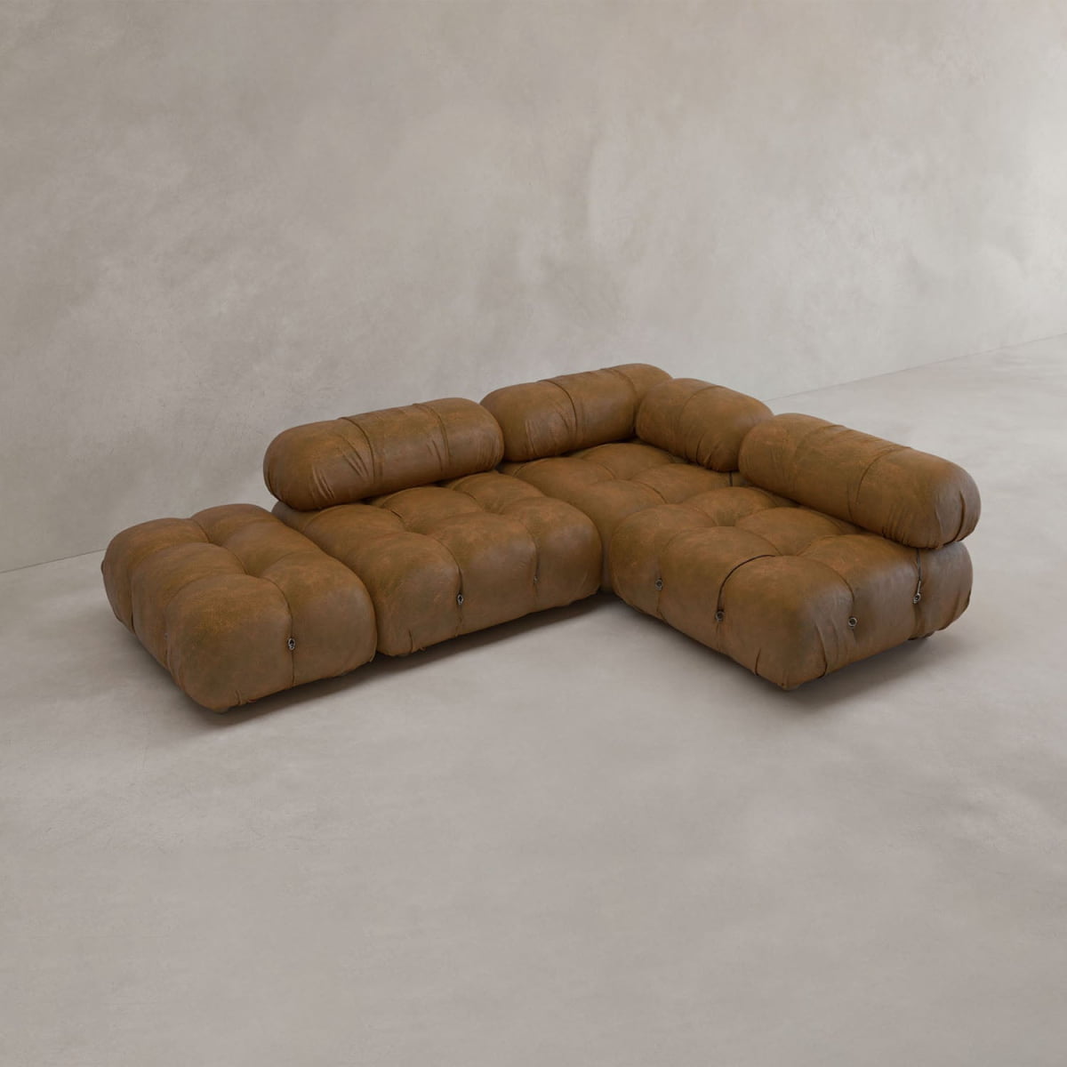 The Belmont Sofa Combination B is a modular brown leather sectional with tufted cushions and rounded edges, inspired by the classic cloud sofa, displayed on a smooth neutral-toned floor against a plain light wall.