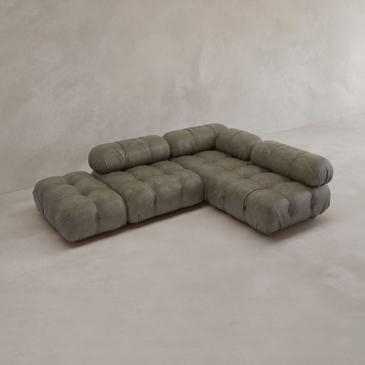 The Belmont Sofa Combination B features plush, tufted cushions in muted olive-green, thick rounded backrests, and an L-shaped modular design—an iconic classic that elevates any living space against light beige walls and floors.