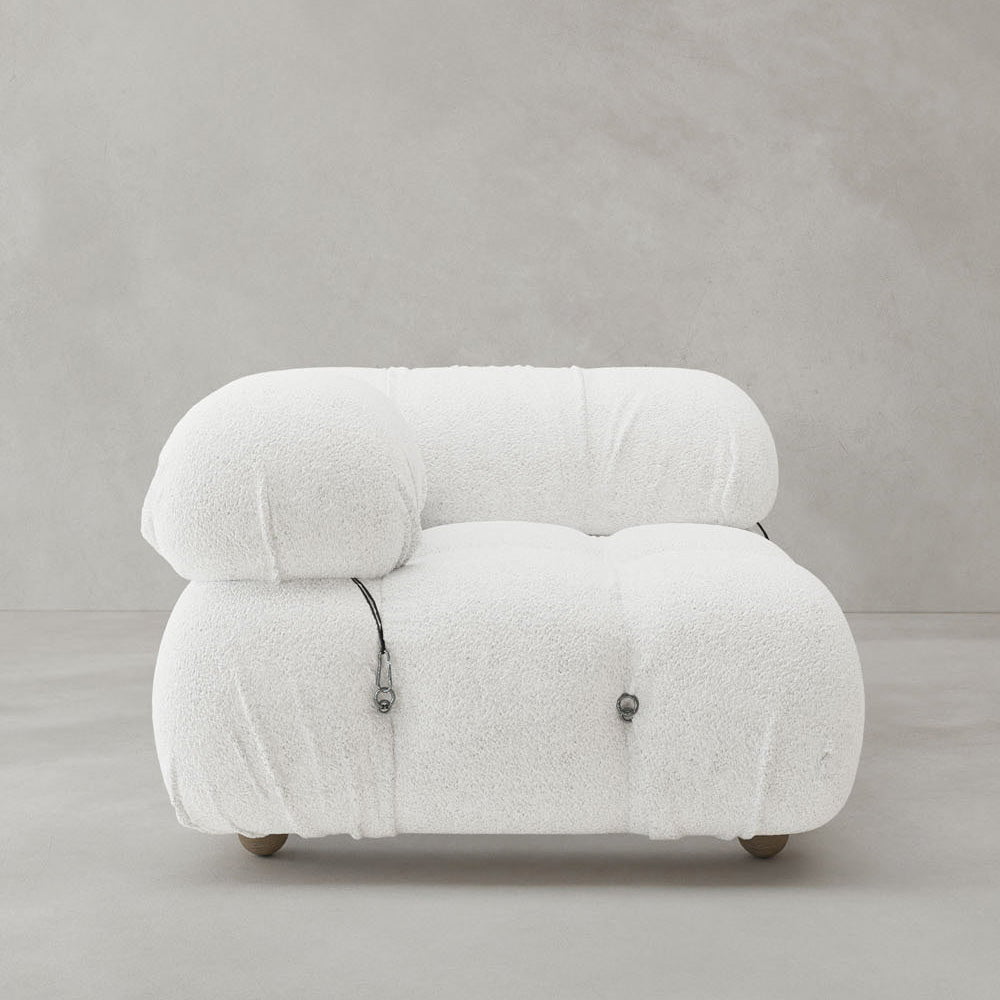 The Belmont Sofa Right Armrest is a modern, low-profile white lounge seat with plush textured fabric, rounded shapes, modular design, and two visible front drawstring details, shown against a plain light gray background.