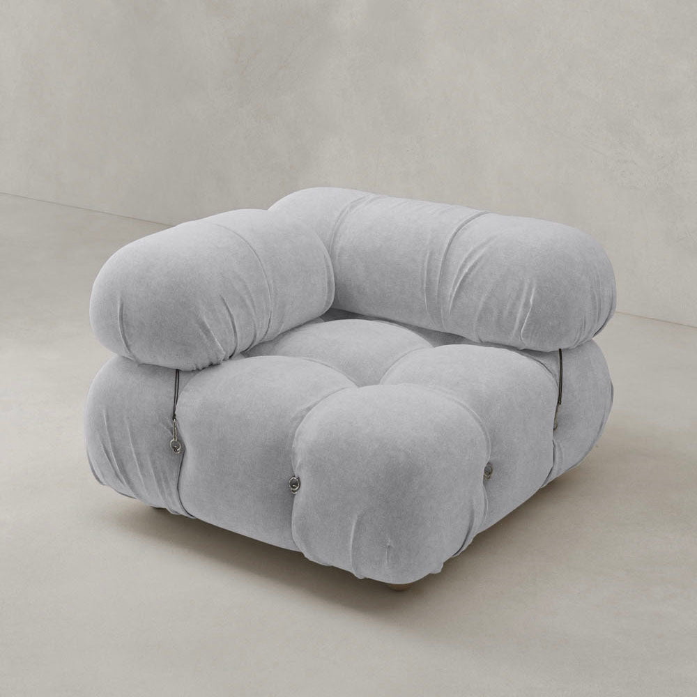 The Belmont Sofa Right Armrest features a modern, modular design with plush, rounded tufted cushions in soft light gray fabric, set on a smooth neutral floor against a matching minimalist wall.