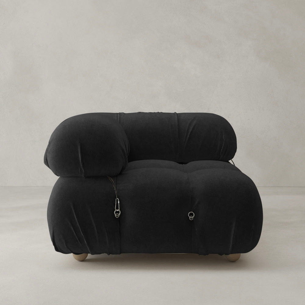 The Belmont Sofa Right Armrest features a modern, oversized design in black with plush, rounded shapes and visible drawstring details, presented against a plain, light-colored background.