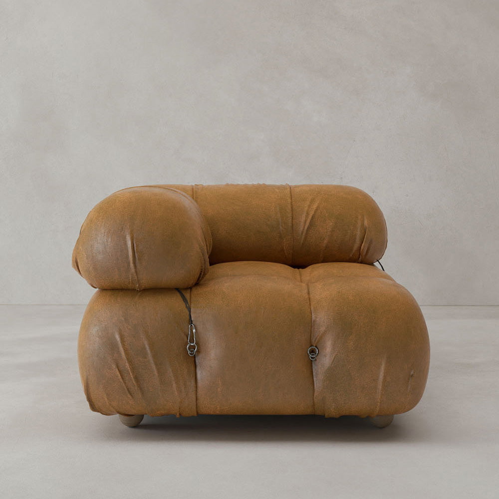 The Belmont Sofa Right Armrest features a modern, low-profile design with oversized tufted brown leather cushions and visible metal clasps, offering iconic classic style against a plain light gray background.