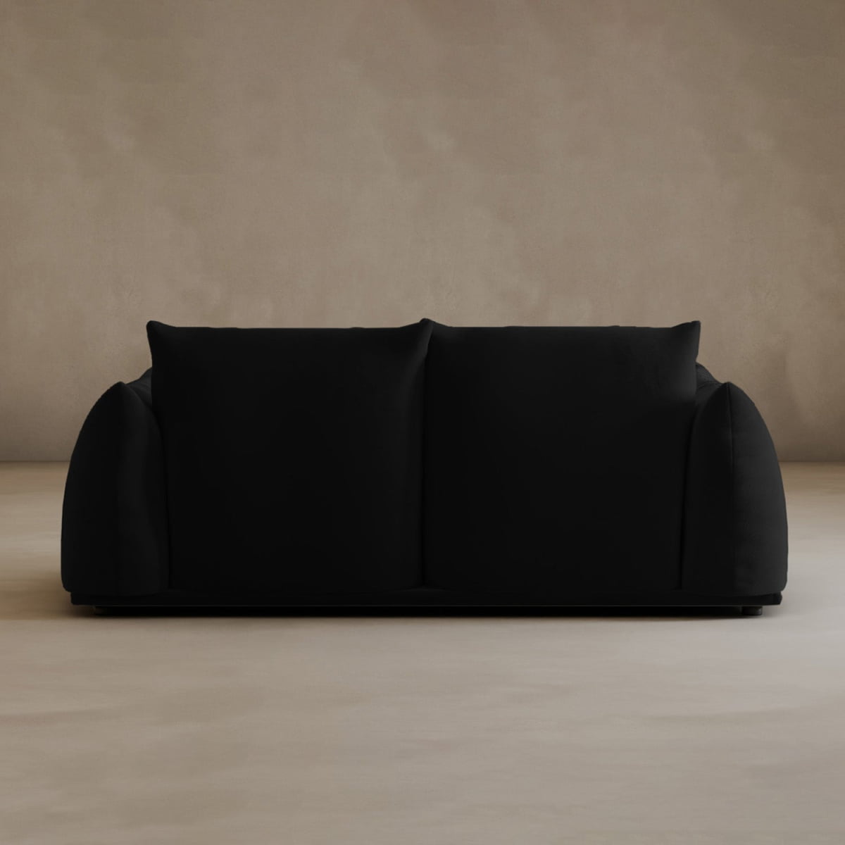 A modern black Calypso Loveseat with plush cushions and rounded arms is centered against a plain beige wall and floor, adding modern elegance to the minimalist setting.